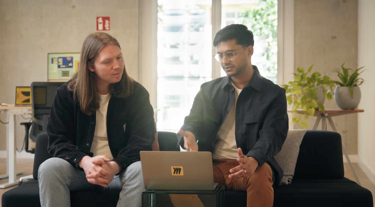 Vihar walking a fellow product manager through his interview business case on a laptop
